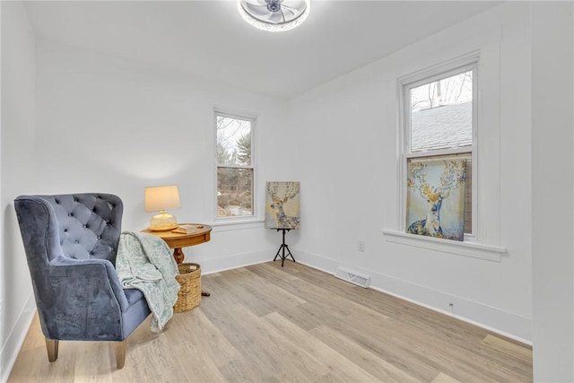 sitting room with visible vents, baseboards, and wood finished floors