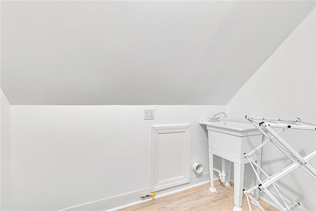 clothes washing area with light wood-type flooring and baseboards