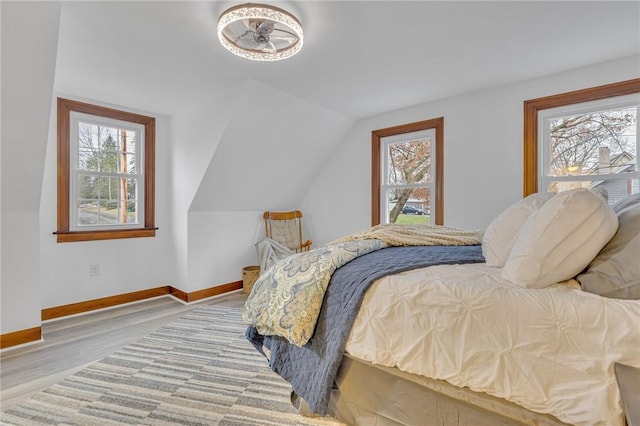 bedroom featuring light hardwood / wood-style floors and lofted ceiling