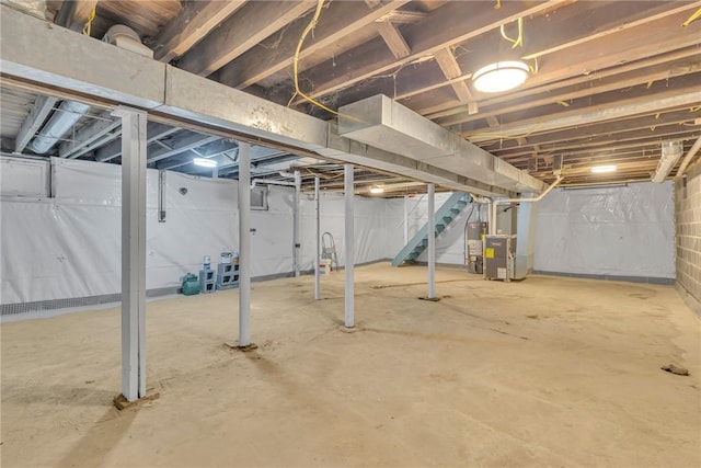 unfinished basement with heating unit and stairs