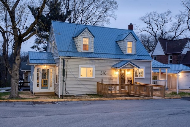 new england style home featuring a chimney and metal roof