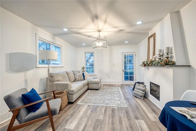 living room featuring light wood finished floors, baseboards, and recessed lighting