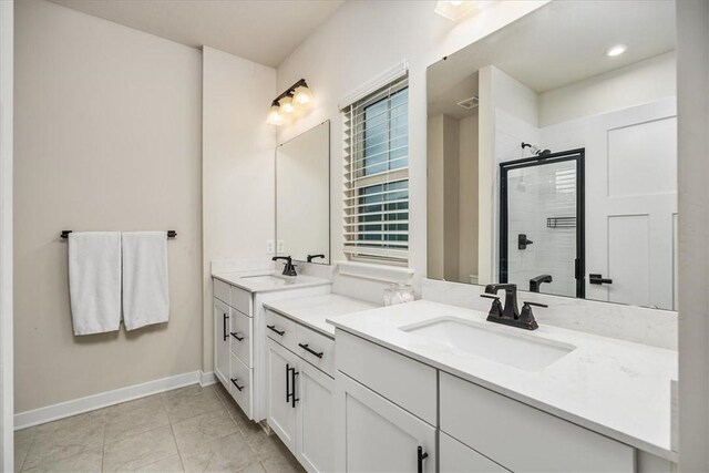 bathroom with a shower with shower door, vanity, and tile patterned floors