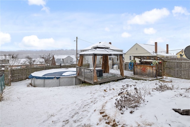 snowy yard featuring a gazebo and a pool side deck