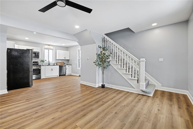 unfurnished living room with light hardwood / wood-style flooring, ceiling fan, and sink