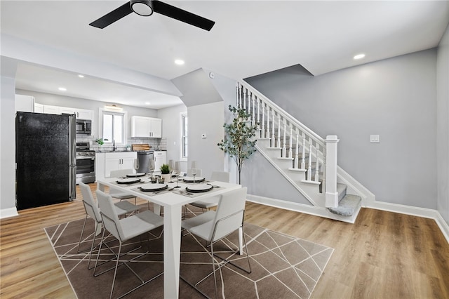 dining space featuring ceiling fan, sink, and light hardwood / wood-style floors