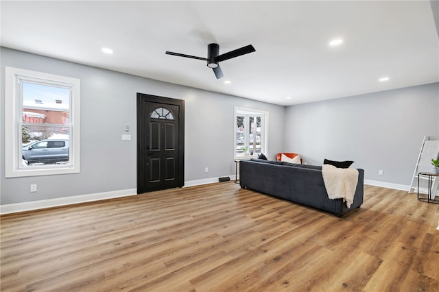 living room featuring light wood-type flooring and ceiling fan