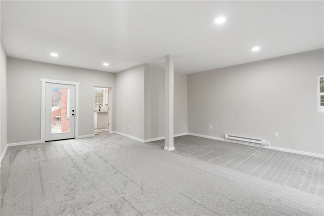 unfurnished living room featuring baseboard heating and light colored carpet