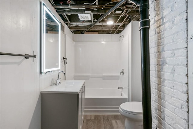 full bathroom featuring vanity, toilet, wood-type flooring, and tub / shower combination