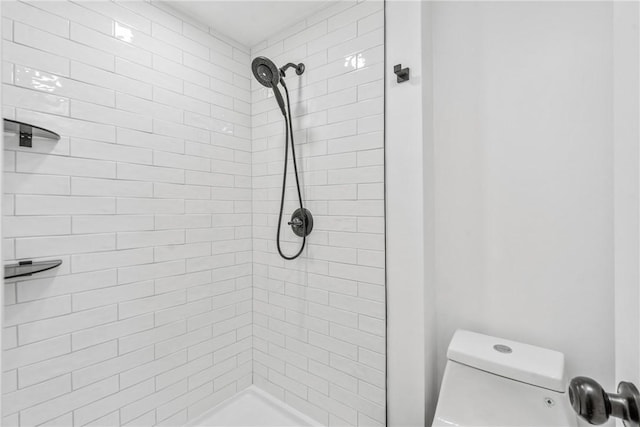 bathroom with toilet and a tile shower