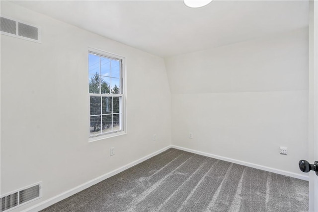 carpeted empty room with vaulted ceiling