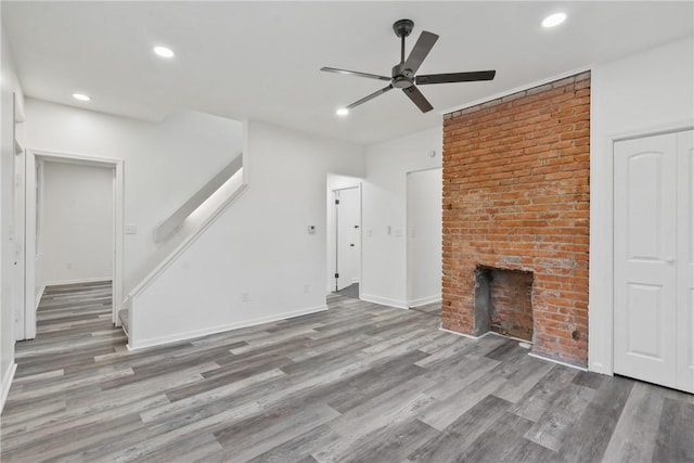 unfurnished living room featuring a fireplace, hardwood / wood-style floors, and ceiling fan