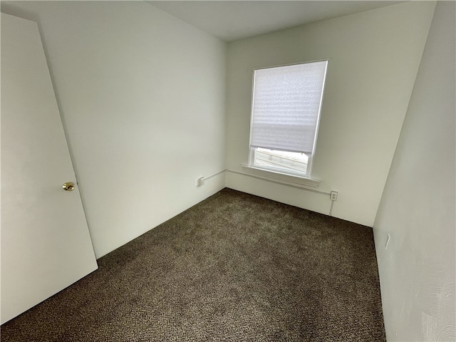 unfurnished room with dark colored carpet