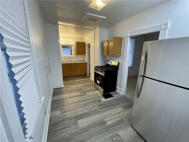 kitchen featuring refrigerator, light wood-type flooring, and gas range