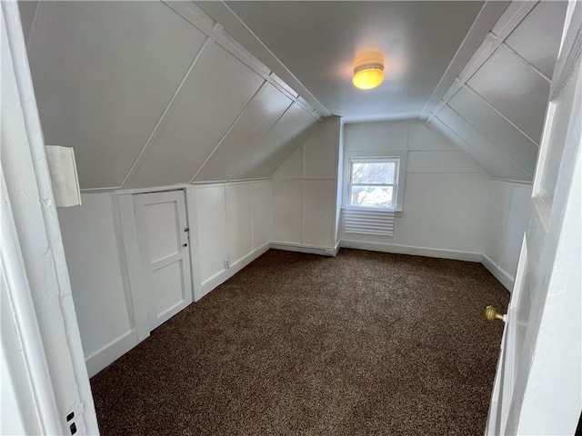 bonus room featuring dark colored carpet and lofted ceiling