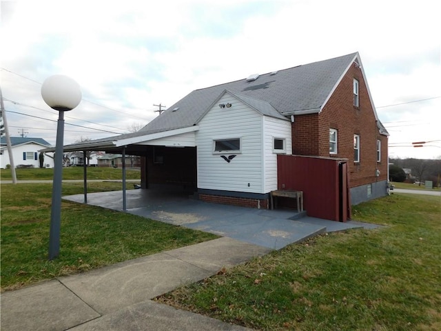 exterior space with a carport and a lawn