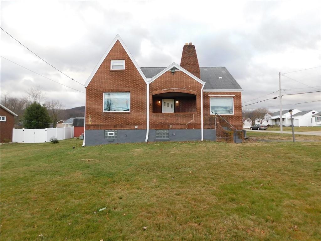 rear view of property featuring a lawn