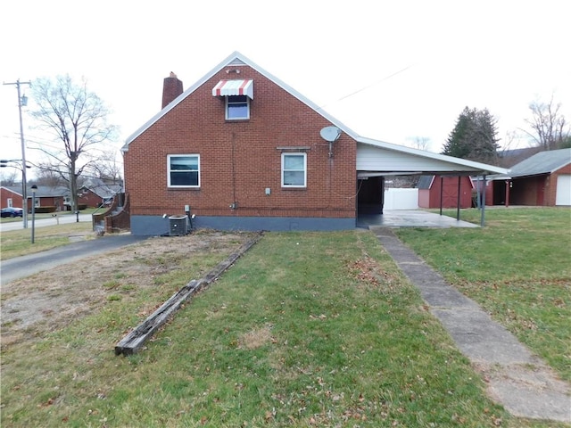 exterior space featuring a yard, central AC unit, and a carport