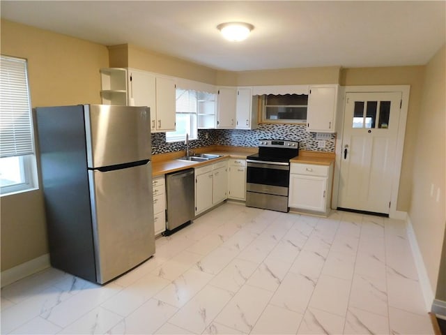 kitchen with white cabinetry, sink, appliances with stainless steel finishes, and tasteful backsplash