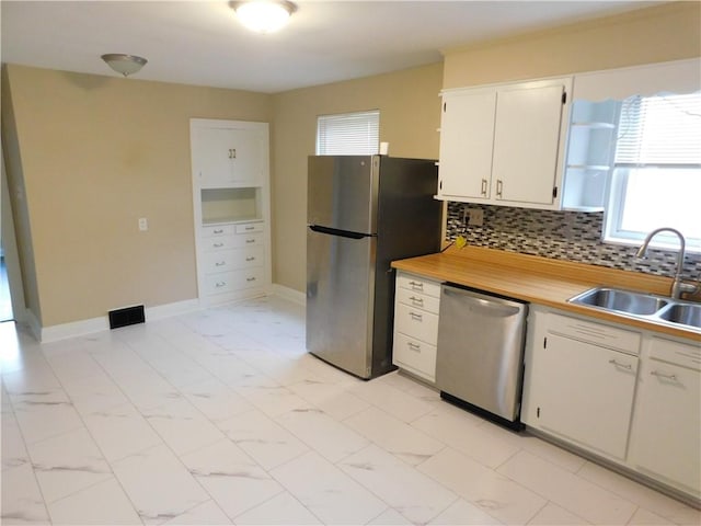 kitchen featuring sink, white cabinetry, stainless steel appliances, and tasteful backsplash