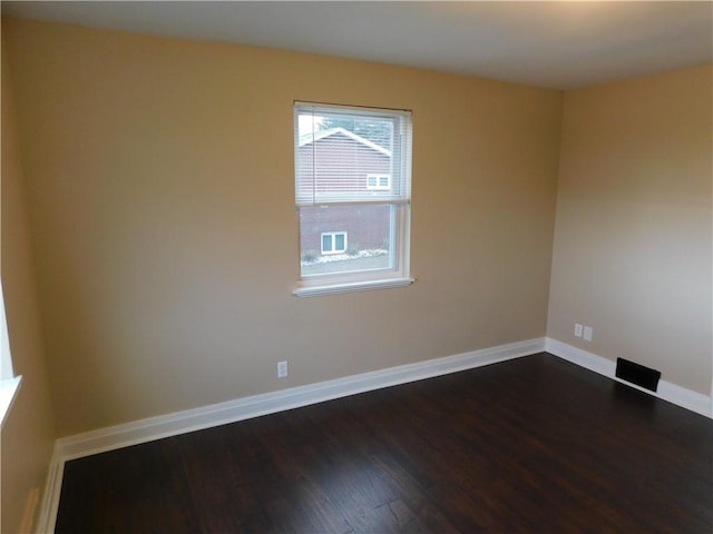 spare room with dark wood-type flooring