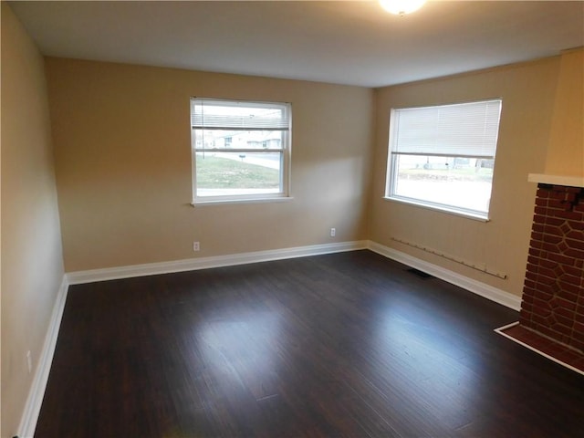 unfurnished room with a healthy amount of sunlight and dark hardwood / wood-style floors