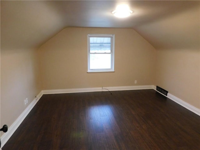 bonus room with dark hardwood / wood-style floors and vaulted ceiling