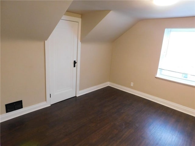 additional living space with dark hardwood / wood-style floors and vaulted ceiling