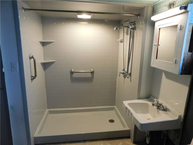 bathroom featuring tiled shower and sink