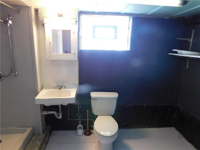 bathroom with a shower, tile patterned floors, toilet, and sink