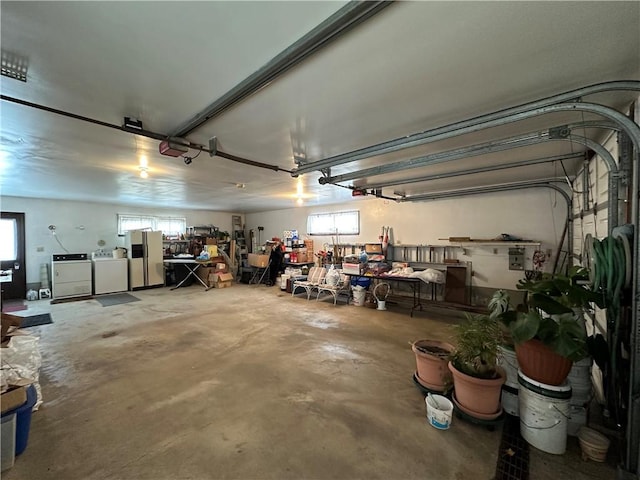 garage with separate washer and dryer and white refrigerator with ice dispenser