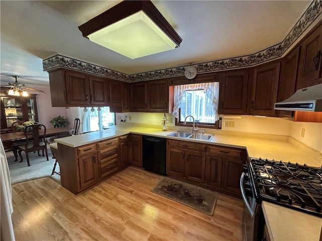 kitchen featuring ceiling fan, stainless steel gas stove, sink, black dishwasher, and kitchen peninsula