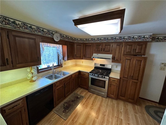 kitchen with sink, black dishwasher, light wood-type flooring, and stainless steel gas range