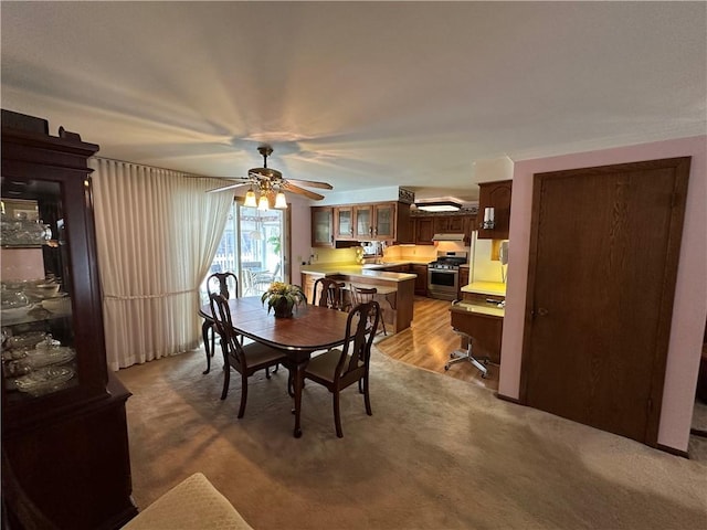 carpeted dining area featuring ceiling fan