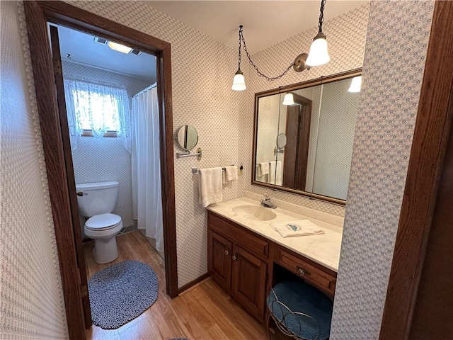 bathroom with hardwood / wood-style flooring, vanity, and toilet