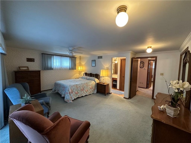 bedroom featuring crown molding, light carpet, and ensuite bath