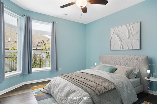 bedroom featuring multiple windows, ceiling fan, and dark wood-type flooring