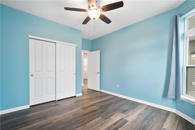 unfurnished bedroom featuring ceiling fan, a closet, and dark wood-type flooring