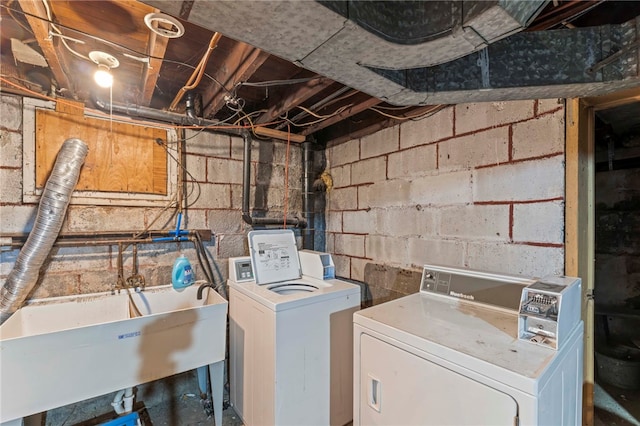 clothes washing area with washing machine and dryer and sink