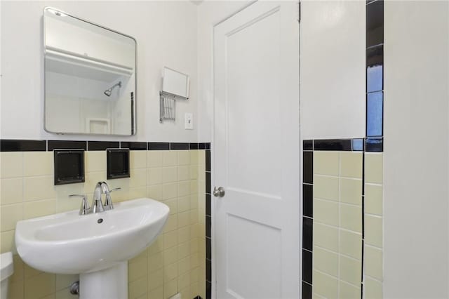 bathroom with sink and tile walls