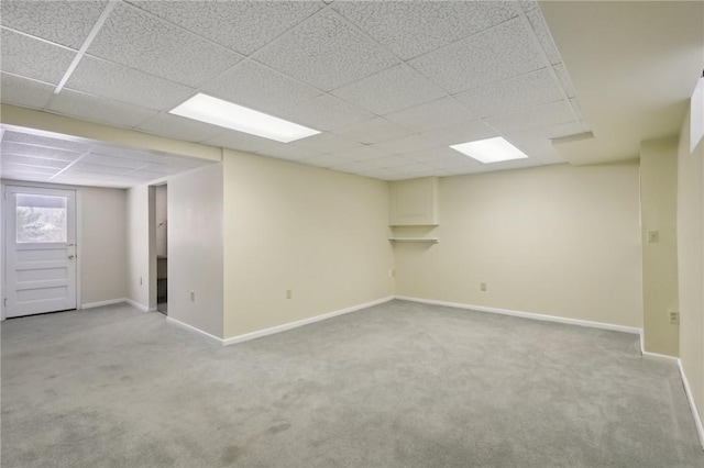 basement featuring a drop ceiling and light colored carpet