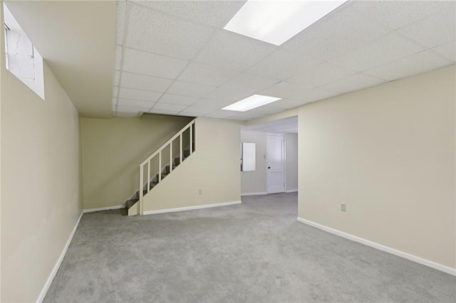 basement with light colored carpet and a drop ceiling