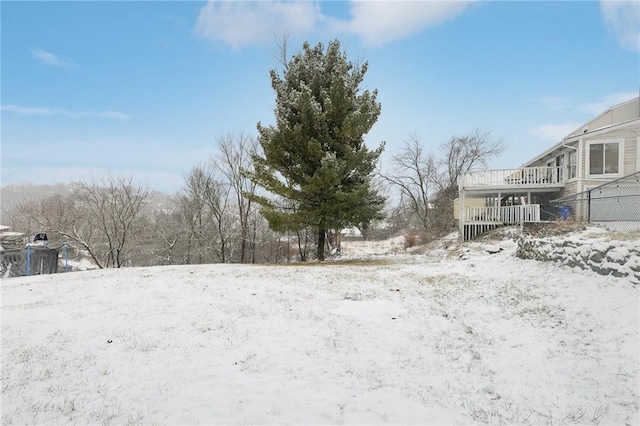 yard layered in snow featuring a wooden deck