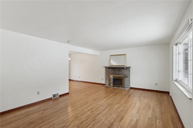 unfurnished living room featuring a fireplace and light wood-type flooring