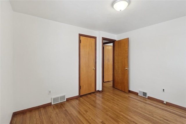 empty room with light hardwood / wood-style flooring