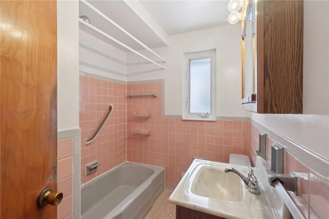 full bathroom with vanity, tile patterned flooring, tiled shower / bath combo, toilet, and tile walls