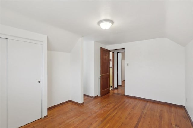 additional living space with wood-type flooring and lofted ceiling