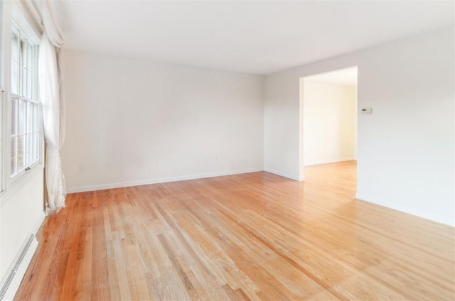 empty room featuring light hardwood / wood-style floors and baseboard heating