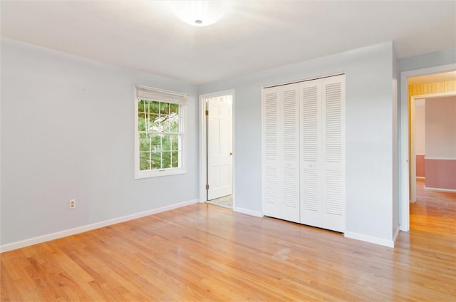 unfurnished bedroom featuring light wood-type flooring and a closet