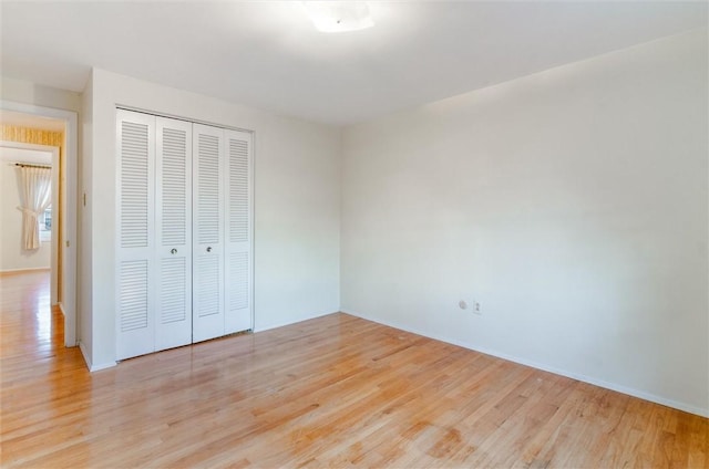 unfurnished bedroom with light hardwood / wood-style floors and a closet